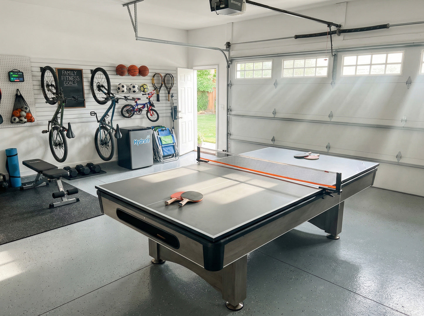 Garage with a ping pong table, exercise equipment, and sports balls.