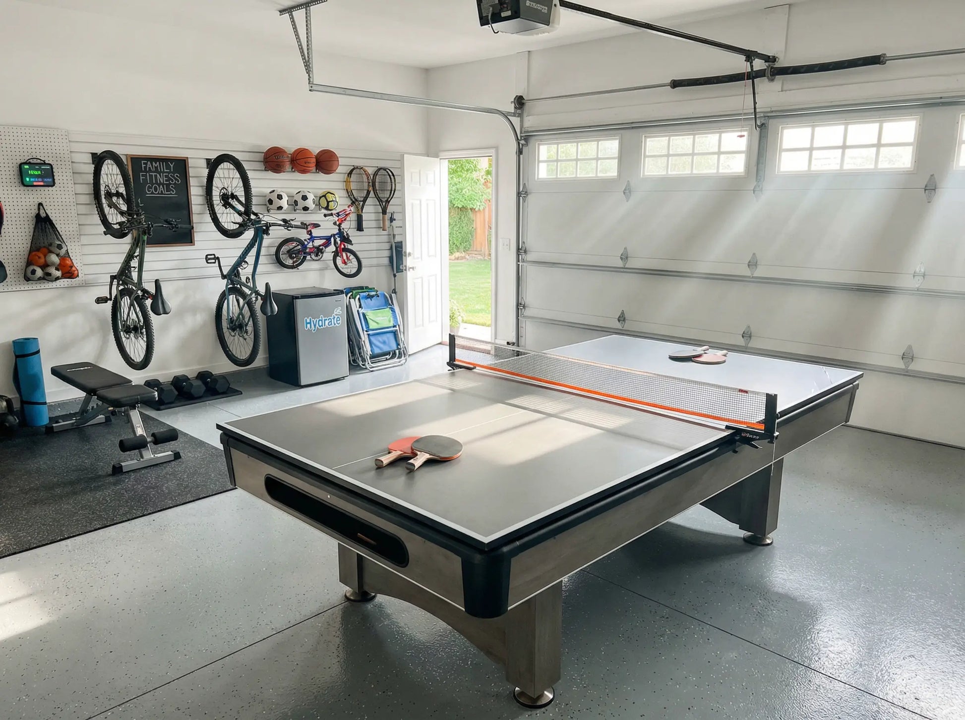 Compact ping pong conversion top installed on a pool table in an organized garage game room