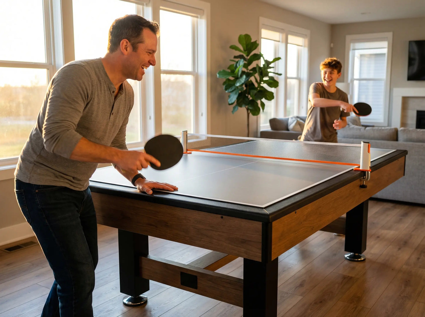 Adult and teenager playing table tennis on a conversion top installed over a pool table