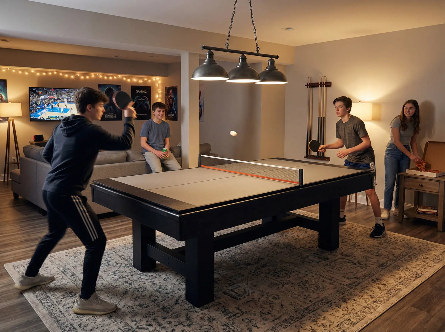 Teenagers playing table tennis on a pool-table conversion top in a basement game room